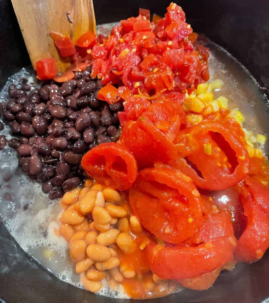 black beans, pinto beans, stewed tomatoes, whole kernel corn in a pot with ground beef