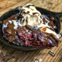 Four healthy pizookie recipes that all pack more than 50 grams of protein. Flavors include s'mores, Twix, triple chocolate, and red velvet, all topped with ice cream.