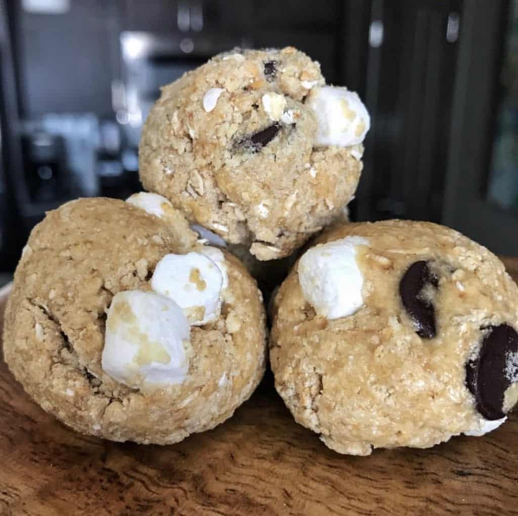 three protein bites on a plate with marshmallows and chocolate chips inside
