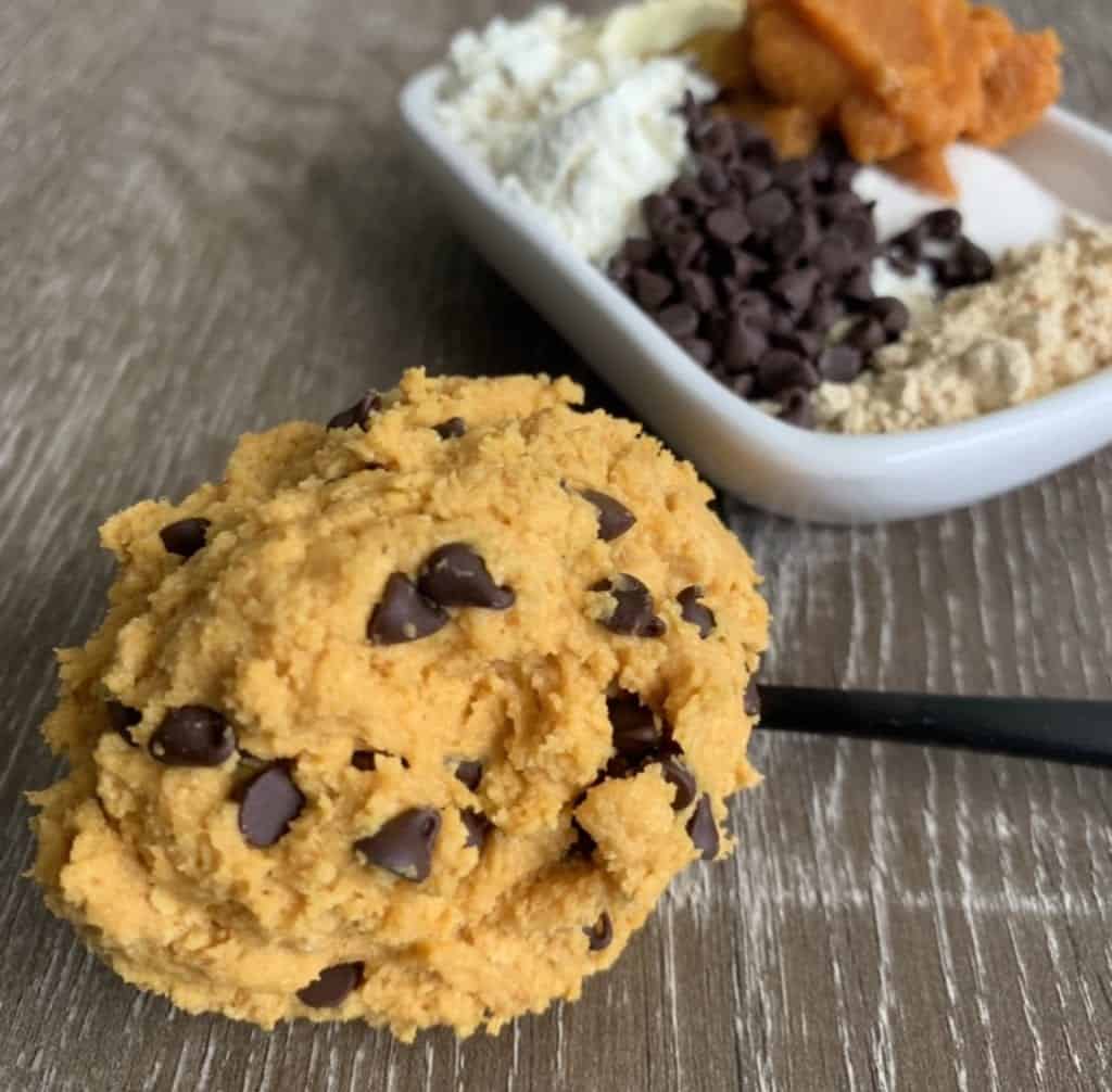 protein cookie dough on a spoon in front of ingredients