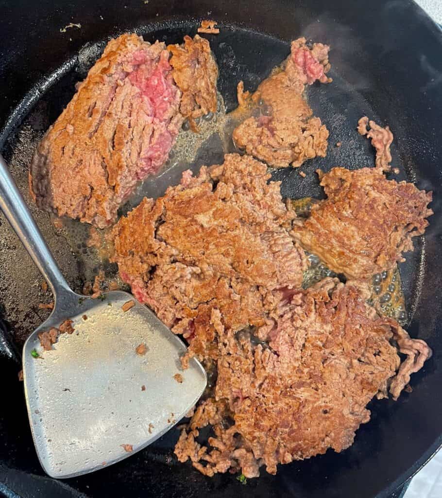 browning ground beef in a cast iron skillet