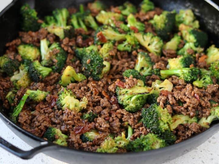 ground beef and broccoli in a cast iron skillet