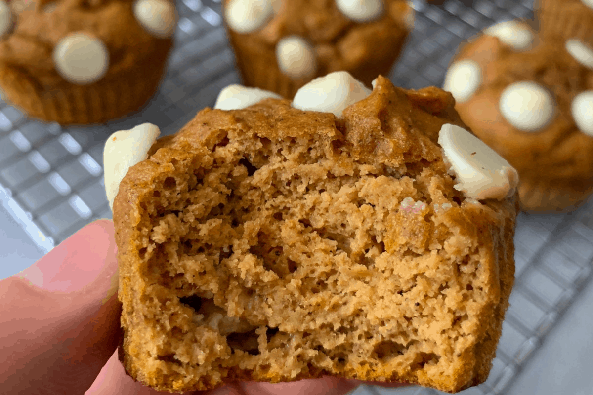 holding a white chocolate pumpkin protein muffins
