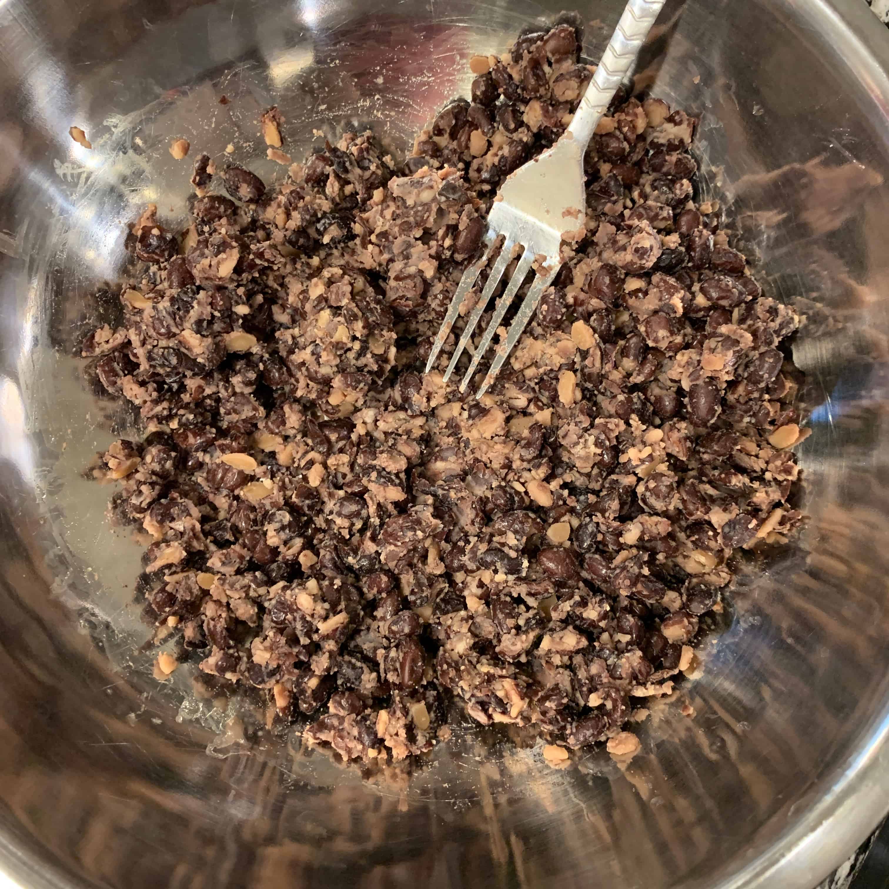 mashed black beans with a fork