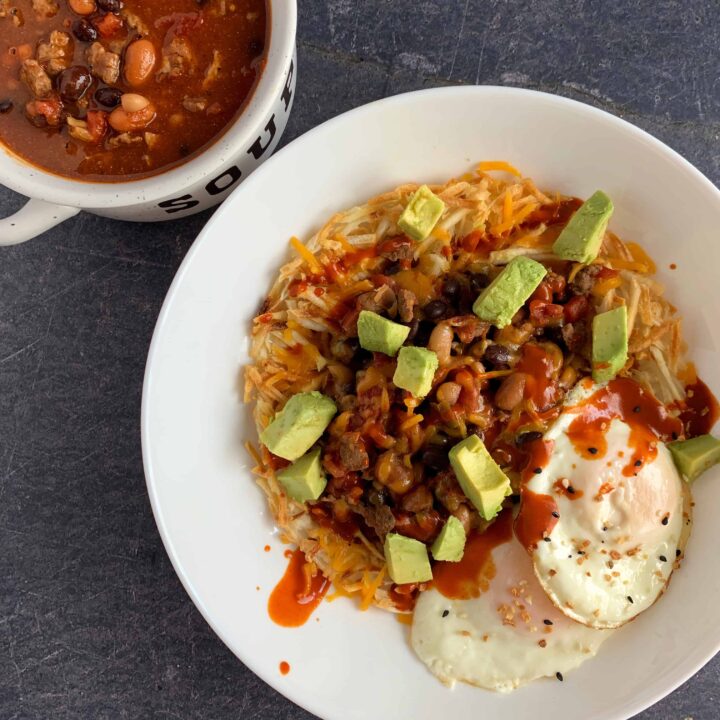 breakfast chili in a bowl and in a larger bowl over hash browns with cheese, avocado, and two fried eggs