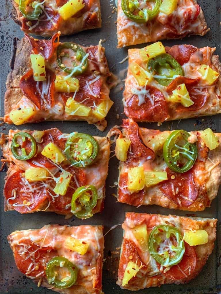 low calorie pizza with pepperoni, jalapeño, and pineapple on a baking sheet cut into 8 slices