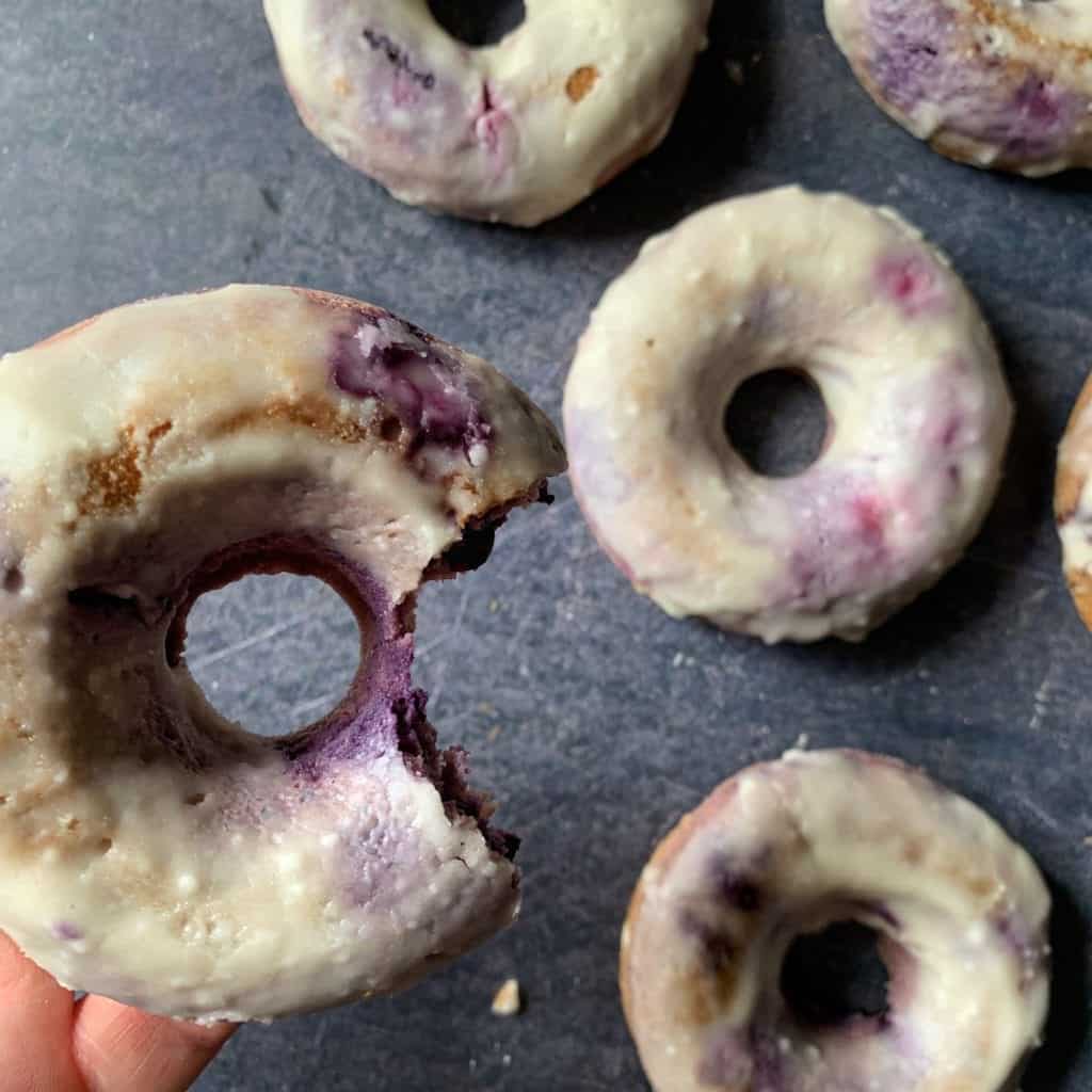 blueberry cake donut with a bite taken out of it