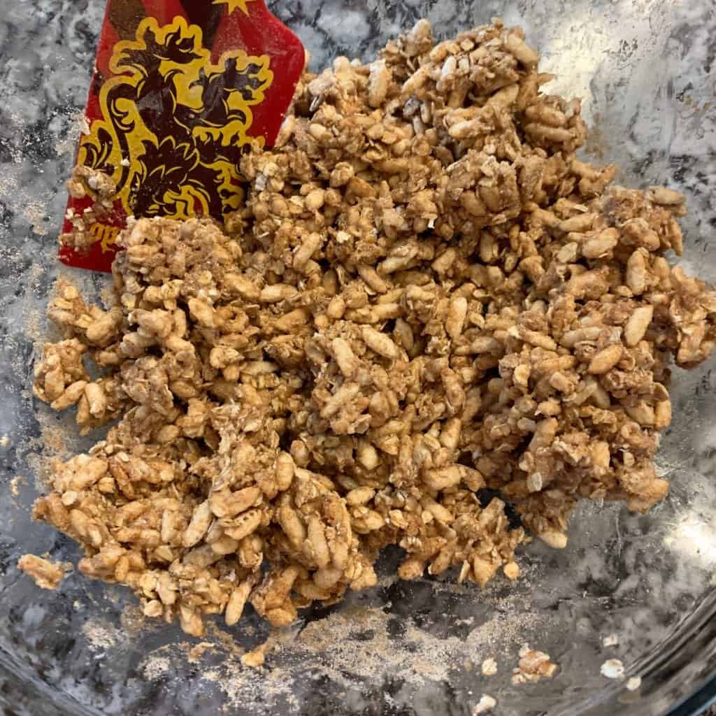 protein granola in a mixing bowl before adding to the baking sheet 