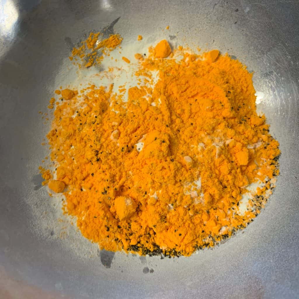 cheddar powder and collagen powder in a mixing bowl with black pepper