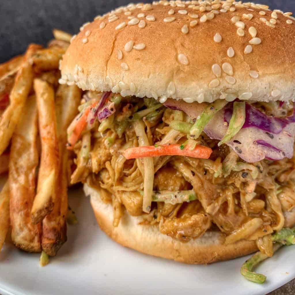 shredded chicken sandwich on a plate with fries
