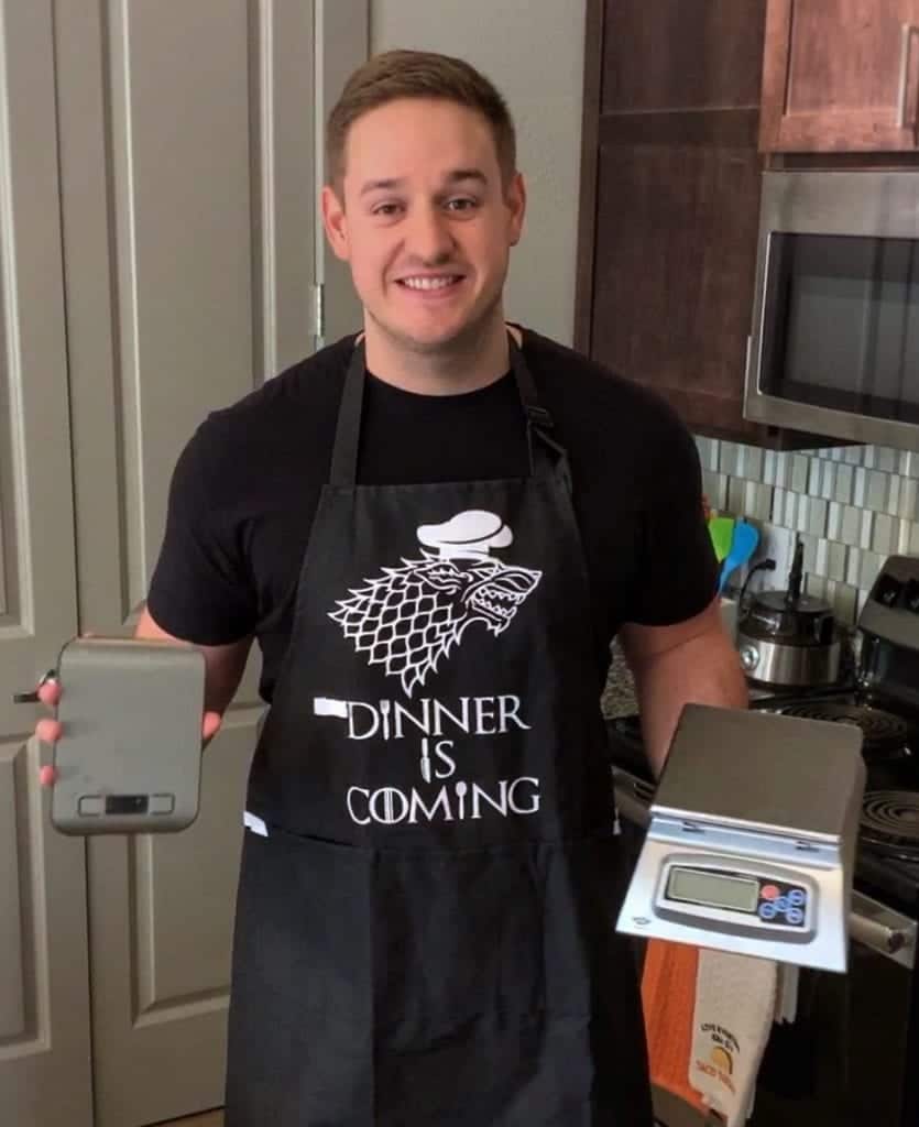 holding two food scales in the kitchen