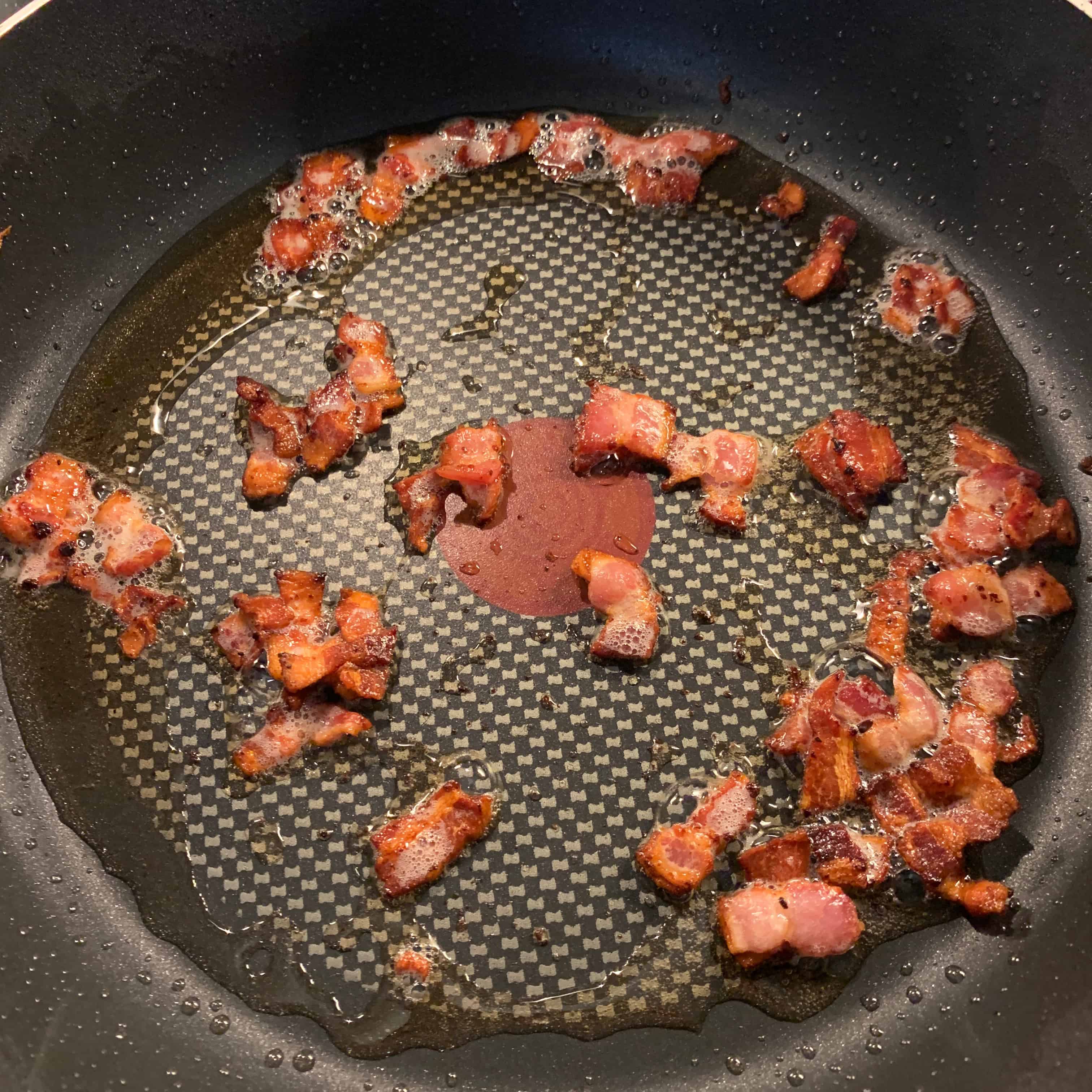 bacon pieces in a frying pan