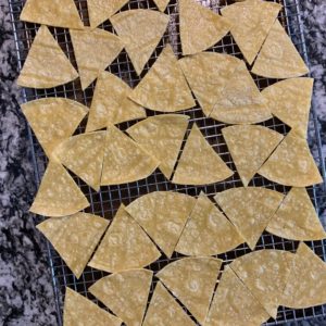thin tortillas cut into triangles on a wire rack before baking