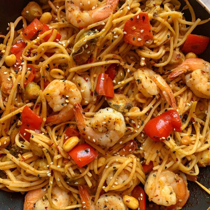 kung pao shrimp with red pepper and brussels sprouts on noodles