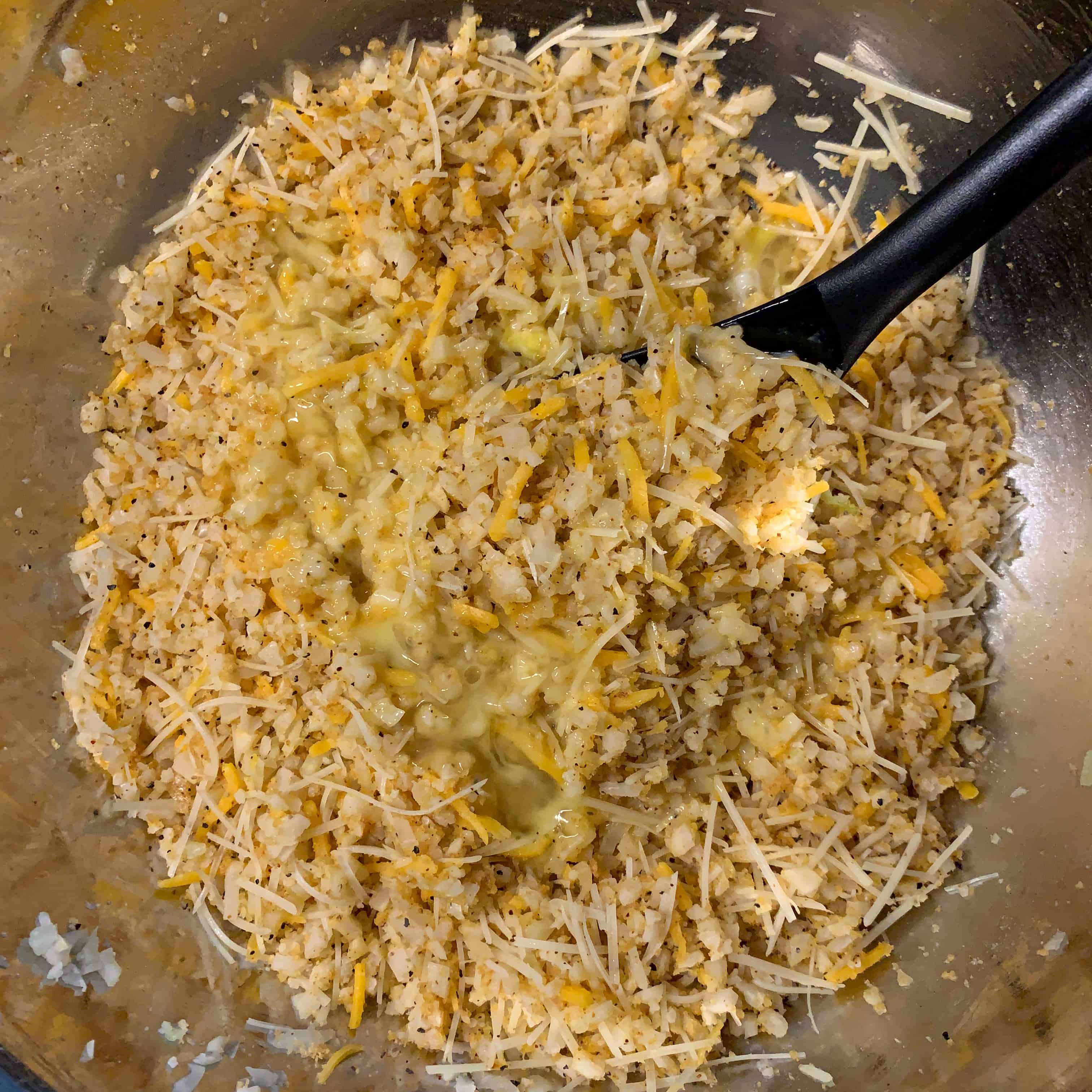 cauliflower rice, eggs, and shredded cheese mixed together in a bowl