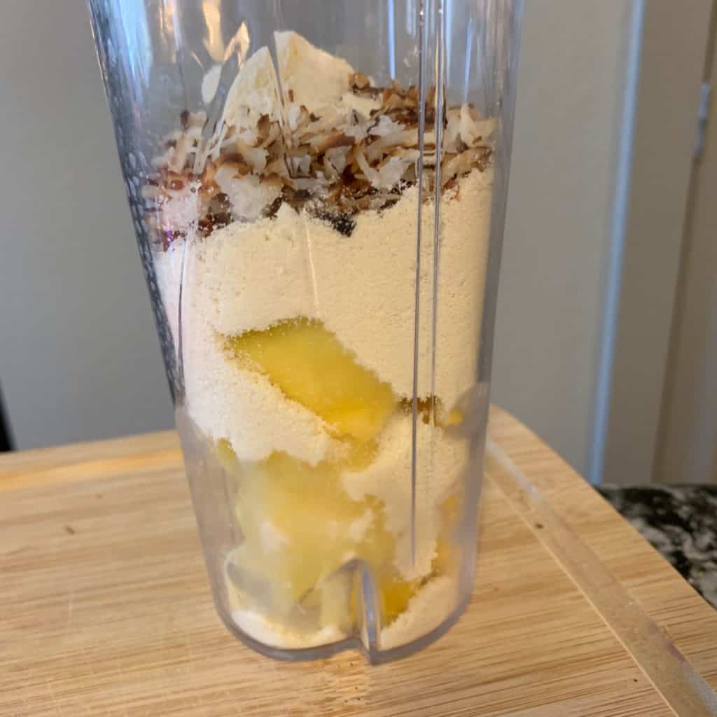 frozen pineapple and mango with toasted coconut and protein powder before adding the milk