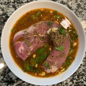 pork tenderloin in a bowl with the marinade