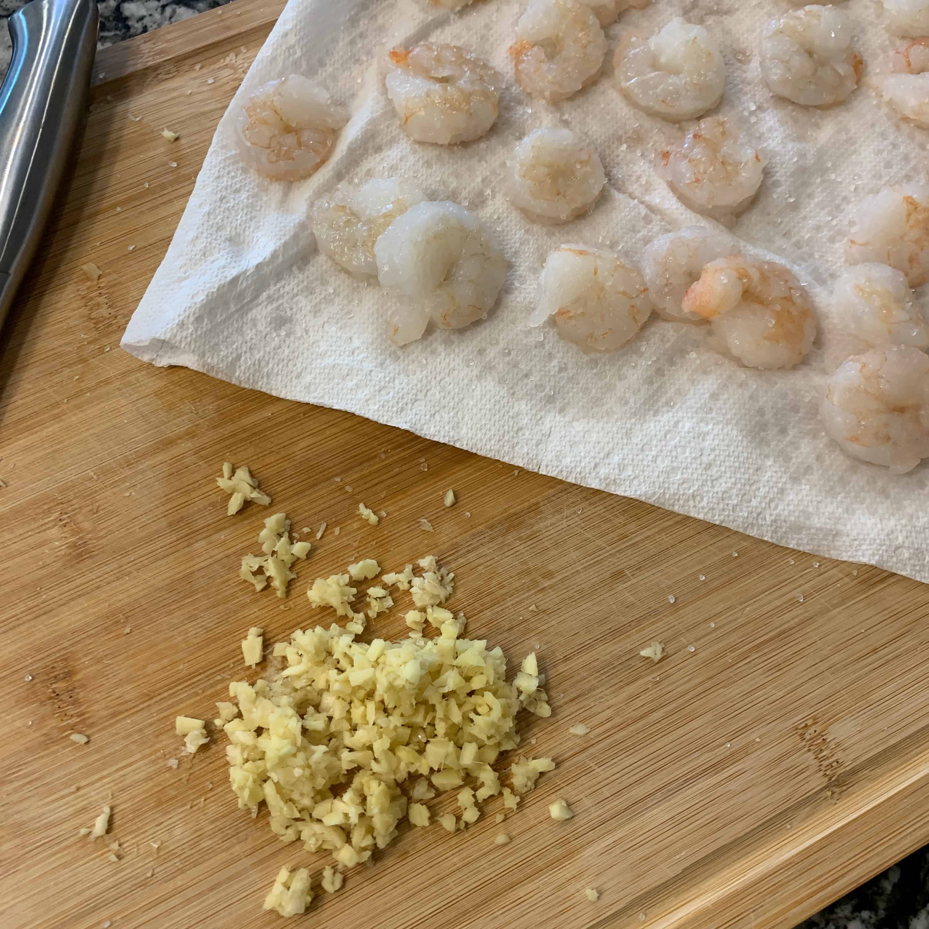 minced garlic and ginger next to thawed shrimp