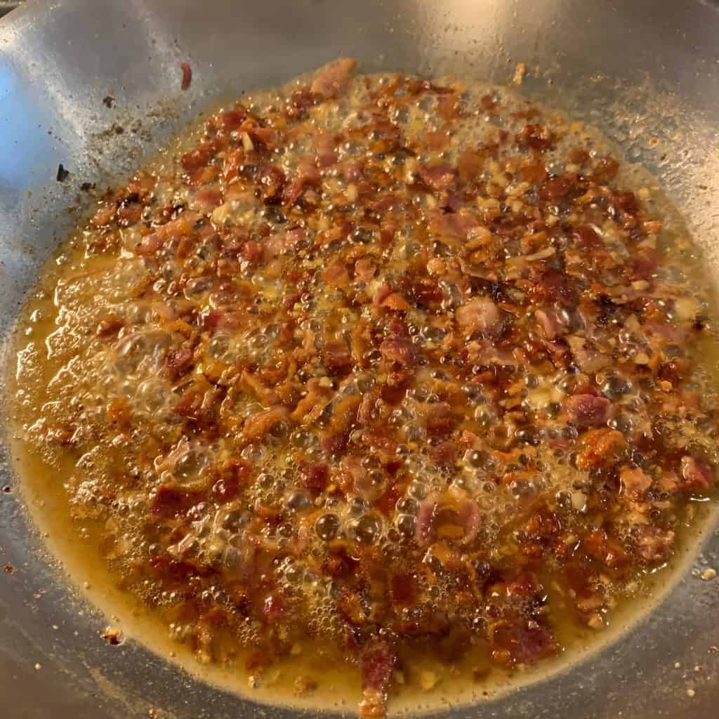 bacon in a pan with garlic and cooking wine