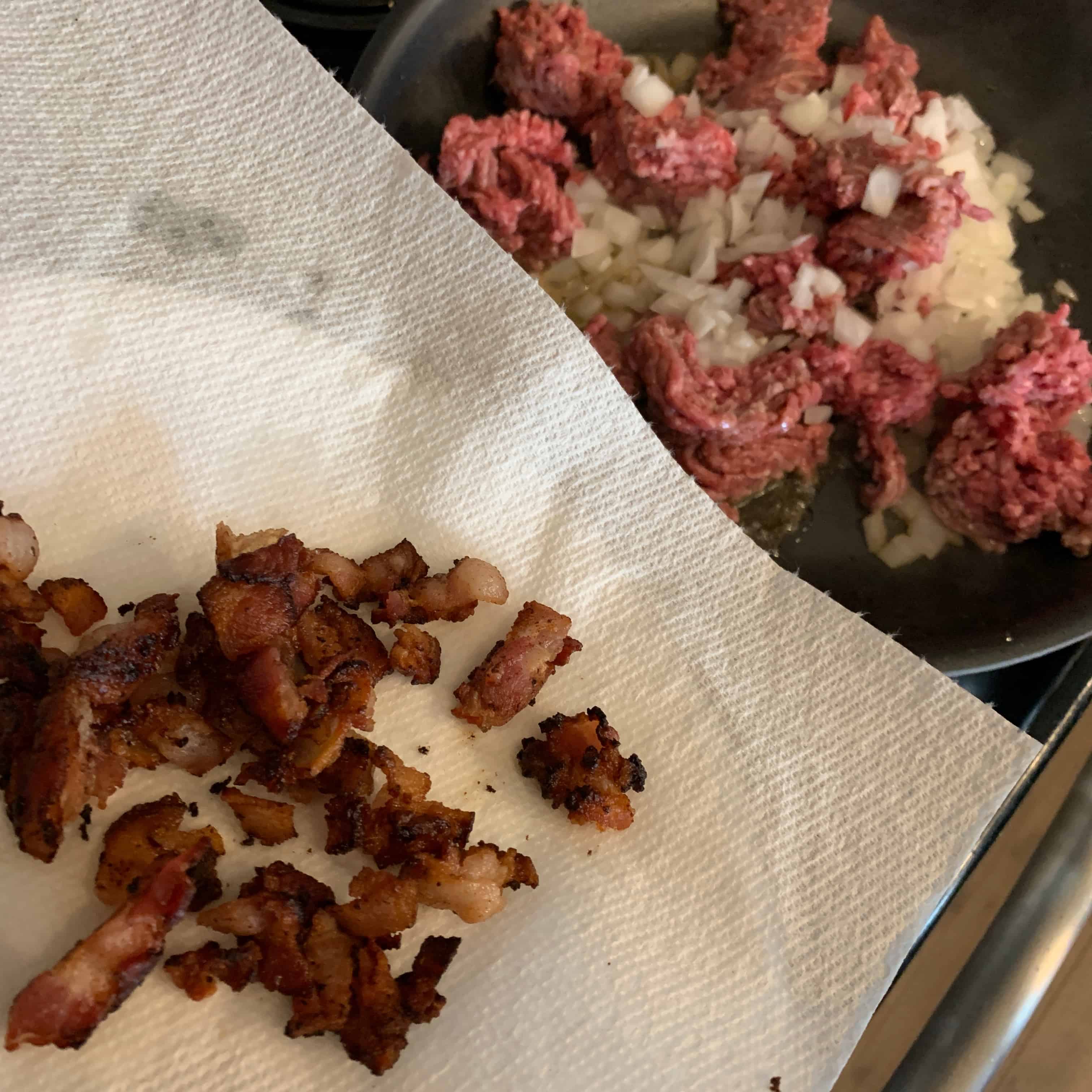 cooked bacon over ground beef and onion