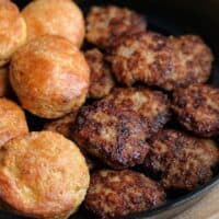 chicken breakfast sausage patties in a skillet with Greek yogurt biscuits