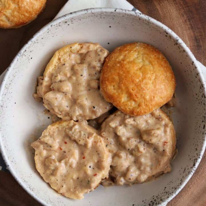 biscuits cut in half in a bowl with healthy sausage gravy