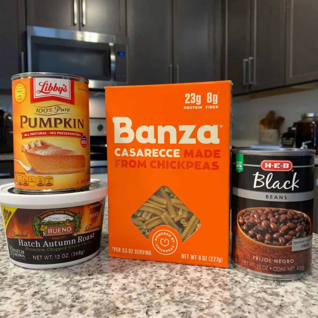 cans of pumpkin and black beans, banza chickepea pasta in the box, and a tub of hatch chiles 