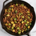 sweet chili ground beef and brussels sprouts in a cast iron skillet
