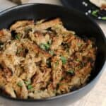 crispy pork tenderloin carnitas in a black bowl with cilantro