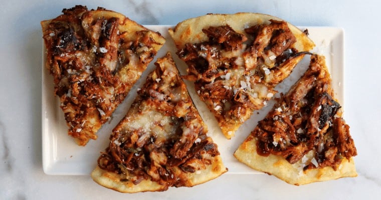 slices of pulled pork pizza on a white plate