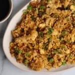 spicy chicken fried cauliflower rice stir fry on a white plate