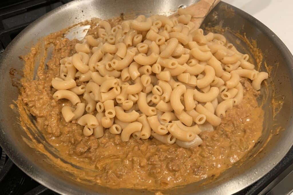 cooked pasta in the ground beef and queso mixture