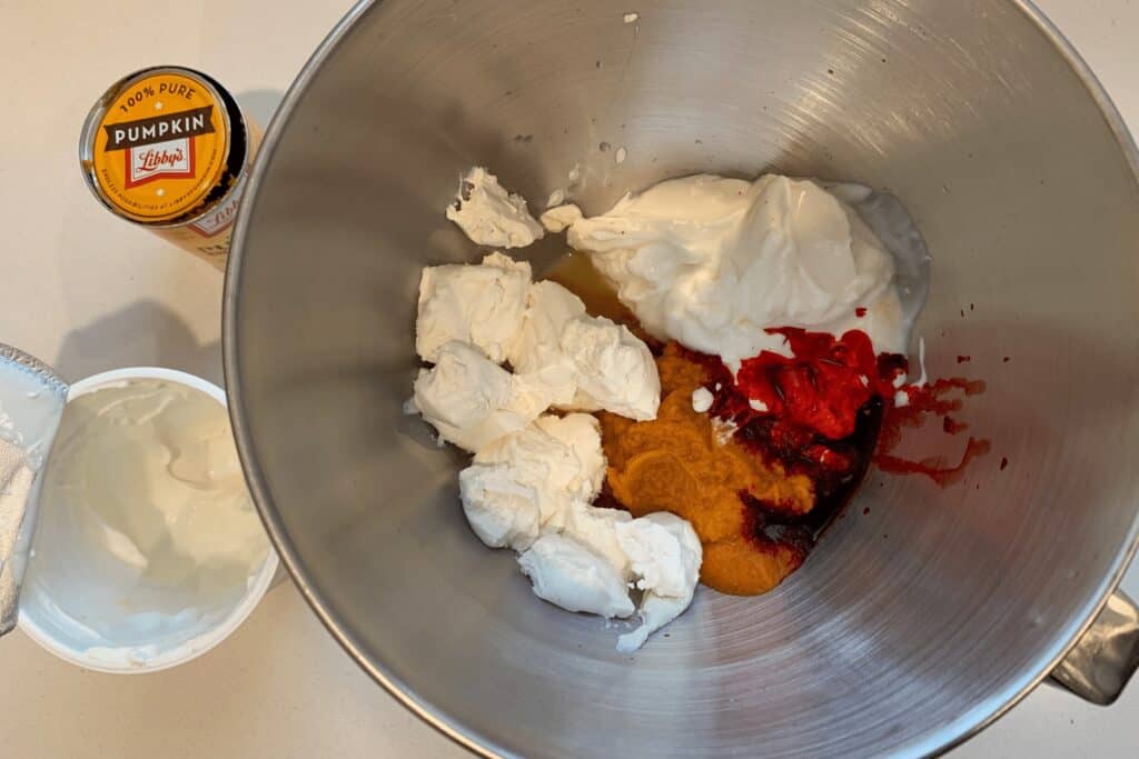 fat free cream cheese, Greek yogurt, canned pumpkin, red food coloring, and white vinegar in a mixing bowl