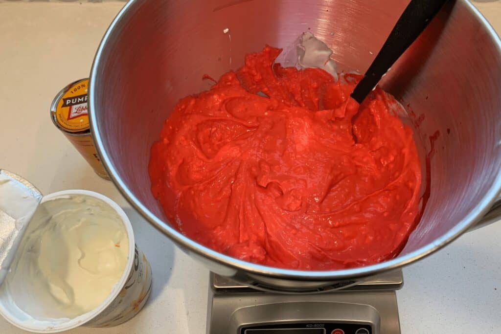 fat free cream cheese, Greek yogurt, canned pumpkin, red food coloring, and white vinegar in a mixing bowl after mixing