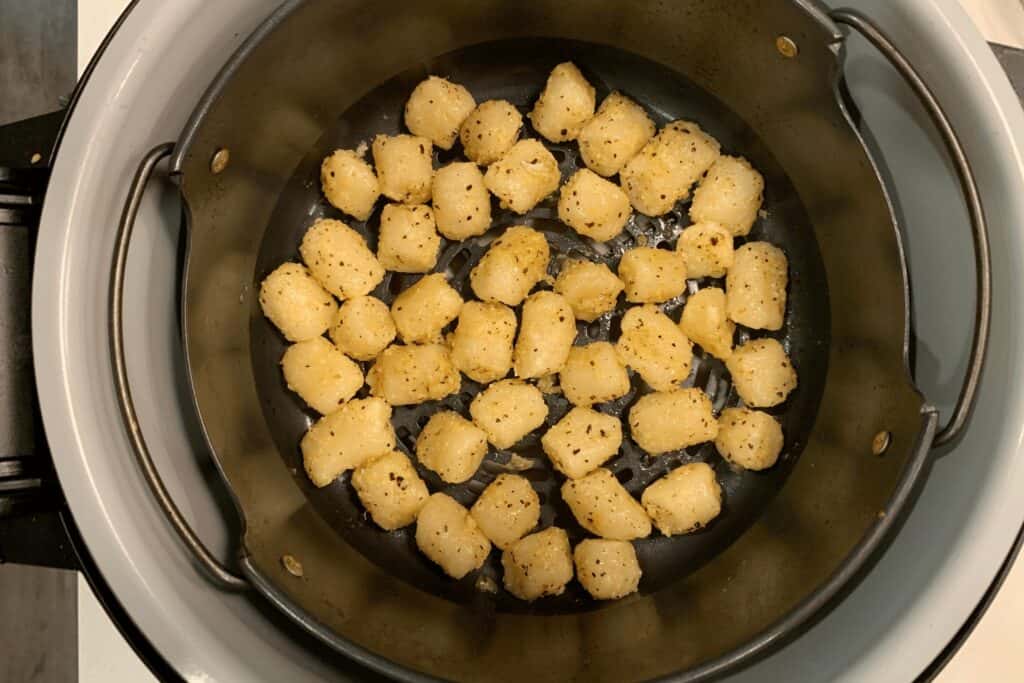 gnocchi back in the air fryer after tossing in olive oil and grated parmesan