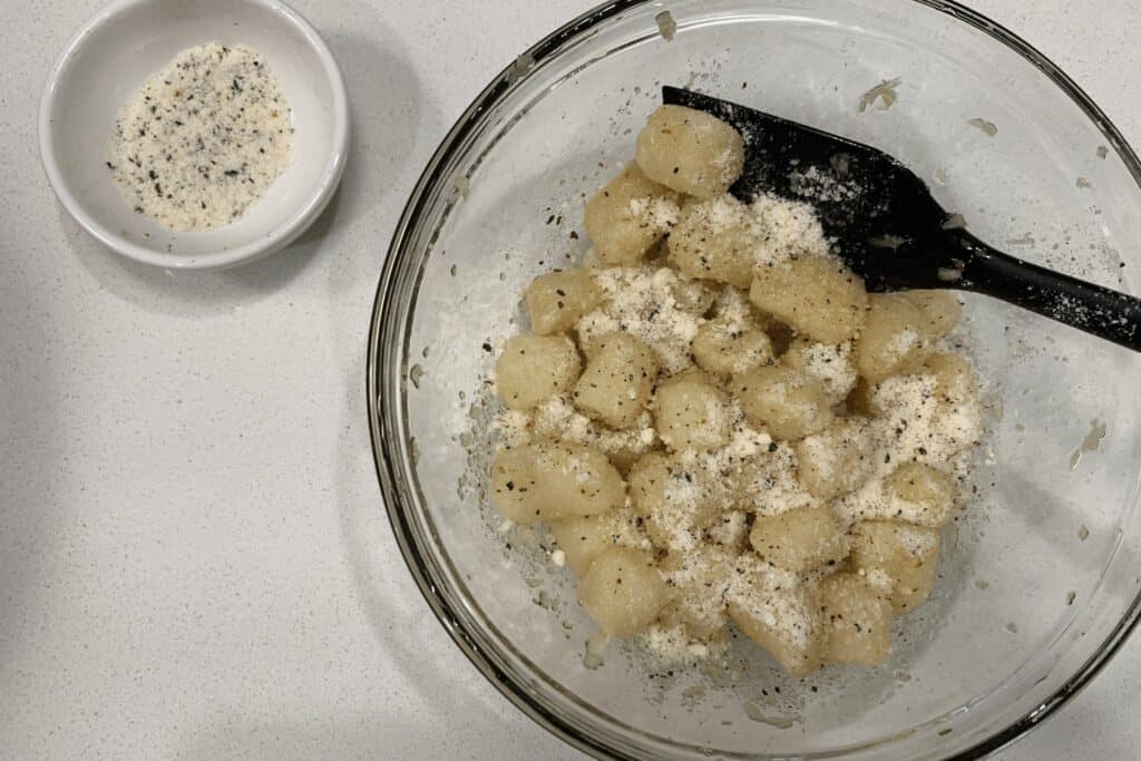 grated parmesan and black pepper sprinkled on the oil coated gnocchi