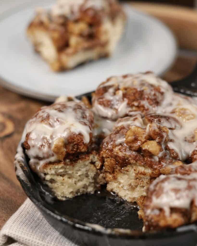 monkey bread in a cast iron skillet with a sugar free glaze on top