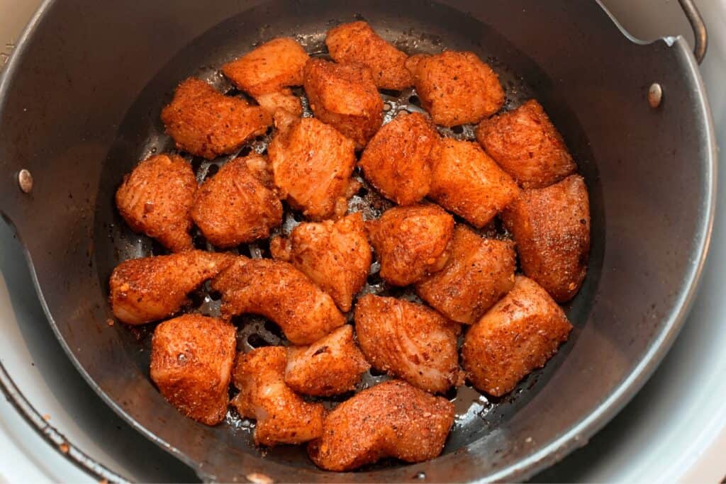 seasoned chicken breast in the basket before frying