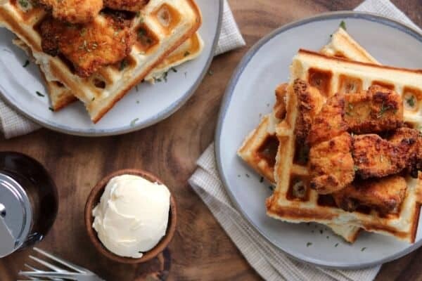 chicken and protein waffles on plates with butter and syrup