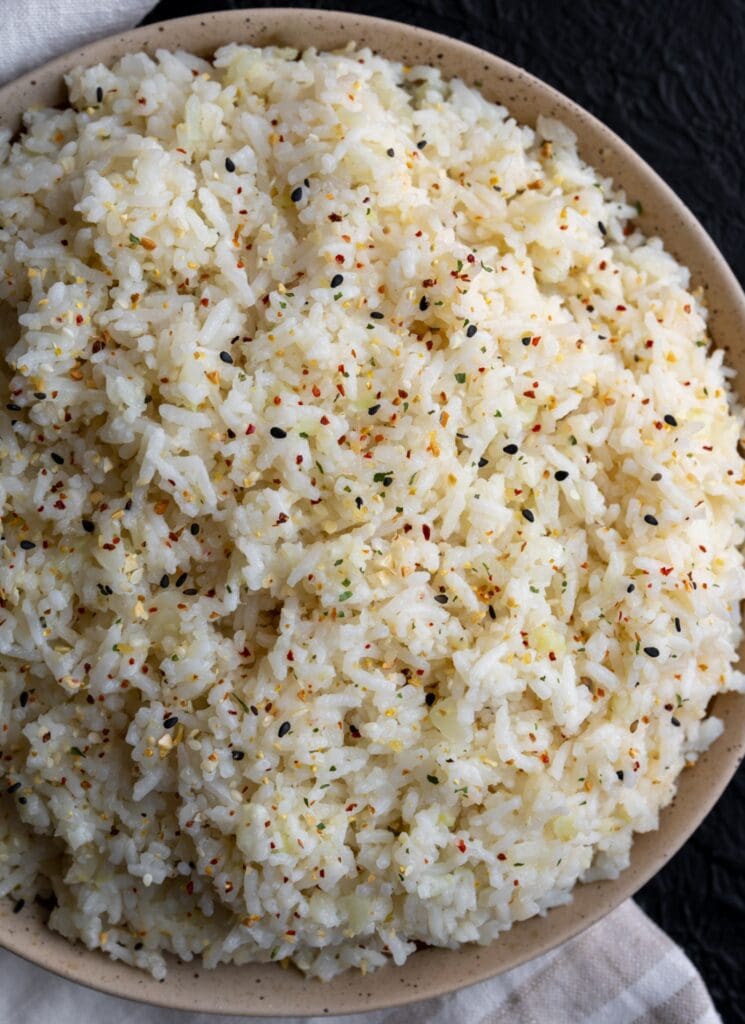 jasmine rice and cauliflower rice blend in a bowl garnished with sesame garlic crunch