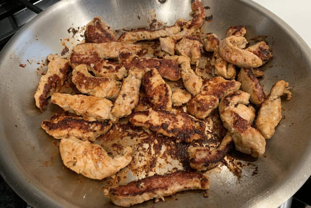 pork tenderloin strips halfway through cooking
