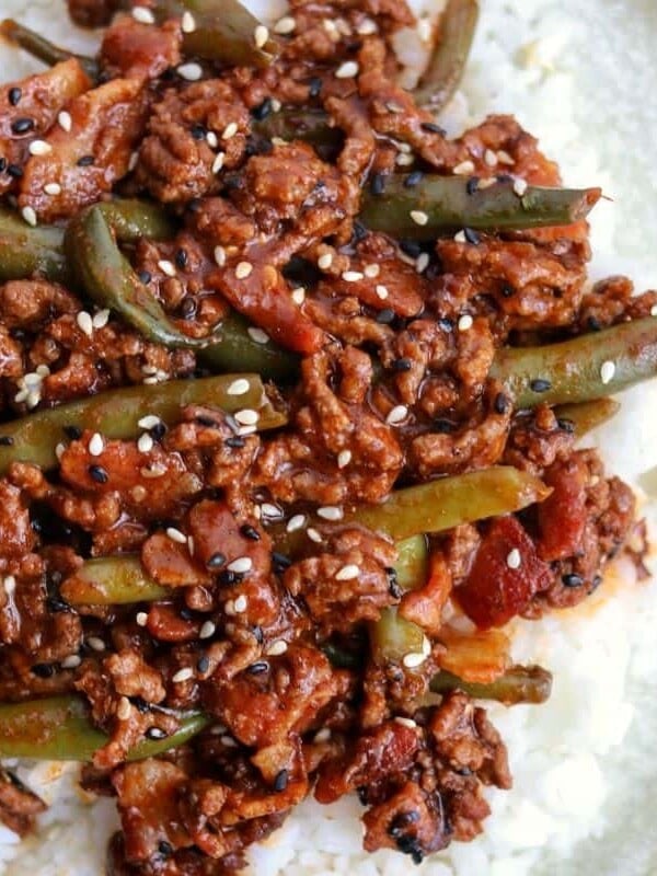 ground beef and green beans on a plate with rice and toasted sesame seeds