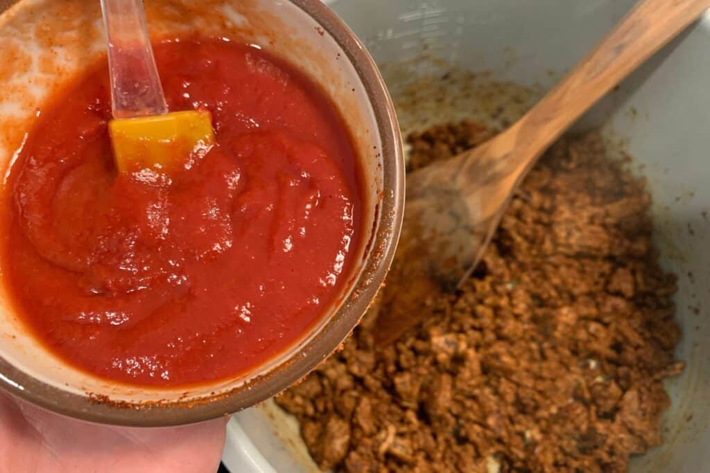 adding tomato paste and lime juice to the cooked ground beef