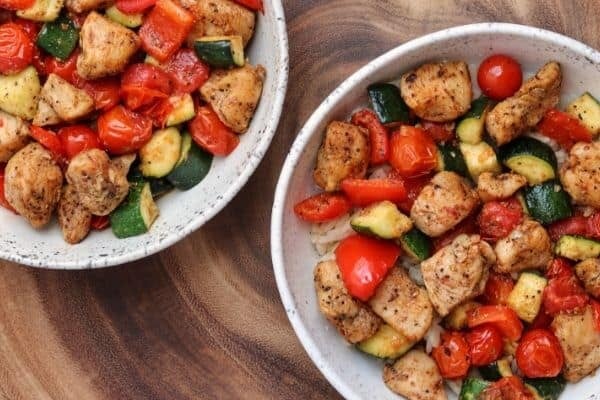 two bowls of cajun chicken and vegetables
