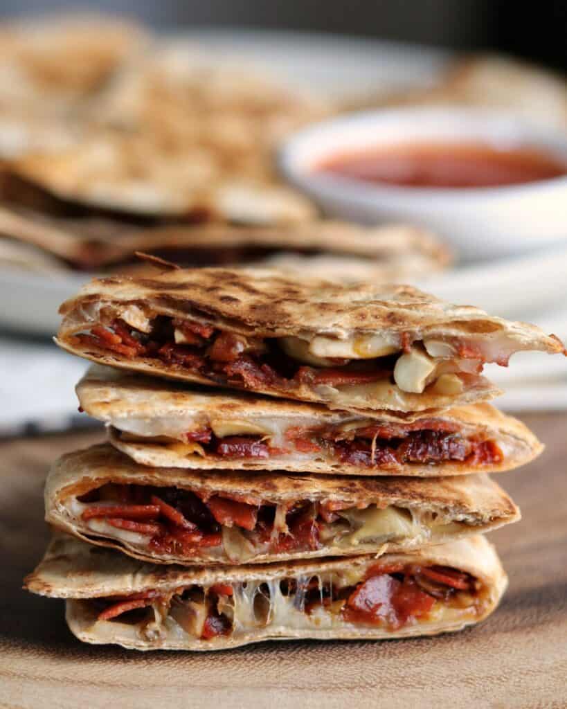 stack of pizza quesadillas with marinara in the background