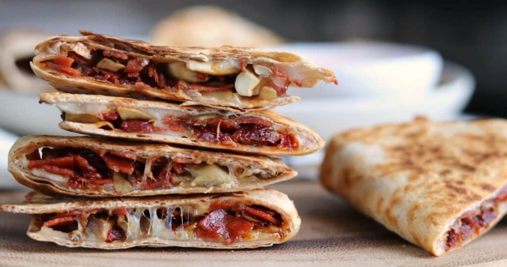 sliced pizza quesadillas on a wooden serving board