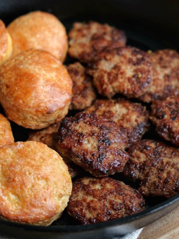 chicken breakfast sausage patties in a skillet with Greek yogurt biscuits