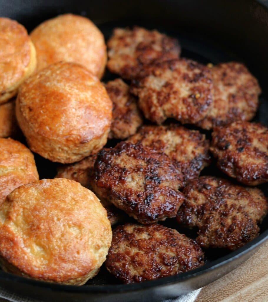 chicken breakfast sausage patties in a skillet with Greek yogurt biscuits