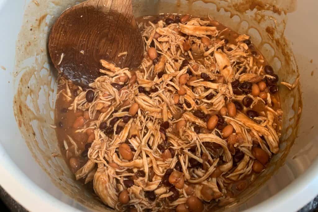 shredded buffalo chicken and beans in a pressure cooker