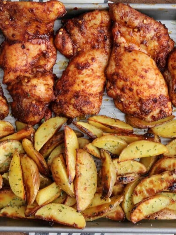 baked chicken thighs and ranch potatoes on a baking sheet